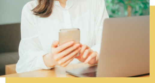 PCとスマホを触る女性